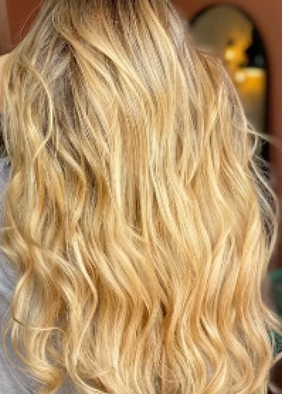 Cabello rubio claro con ondas suaves y textura brillante visto desde atrás