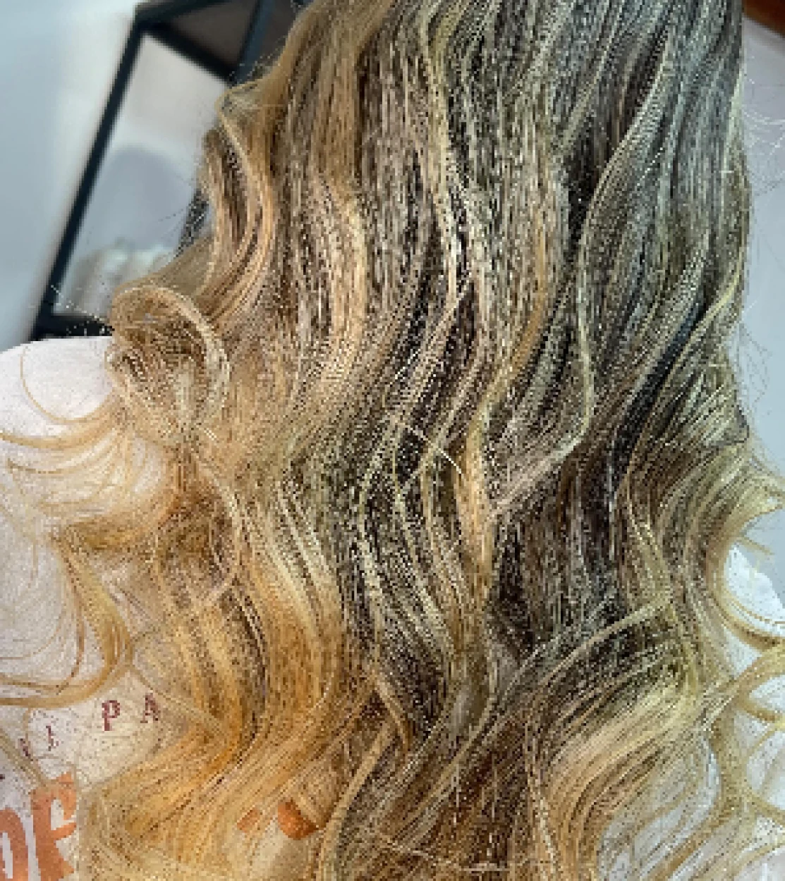 Cabello rubio con ondas grandes y textura brillante visto desde atrás